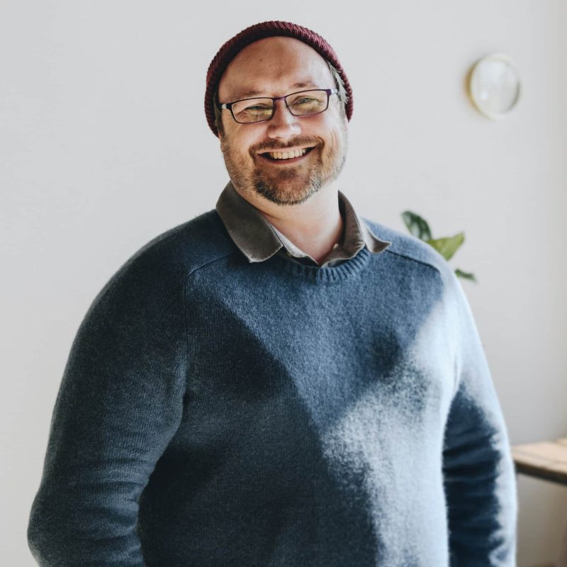 Cheerful man in a blue sweater and a red knitted hat