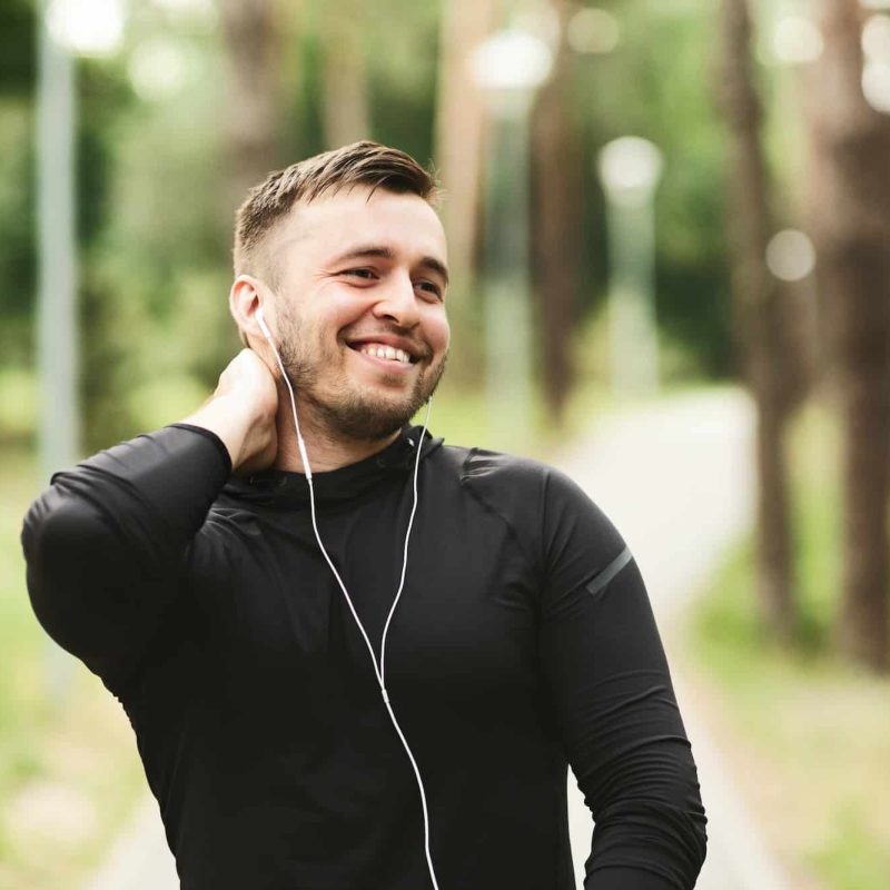 Cheerful young man smiling after successful workout outdoors