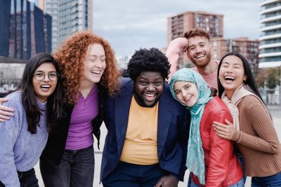 Multiracial happy friends having fun outdoor in city - Main focus on african curvy man