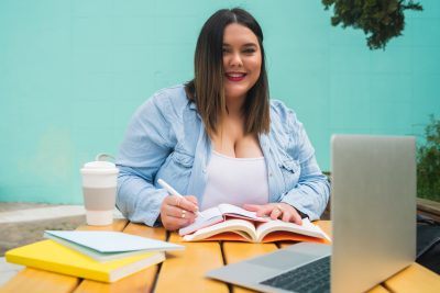 Plus size woman studying at coffee shop.