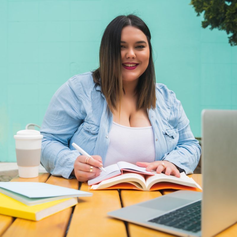 Plus size woman studying at coffee shop.