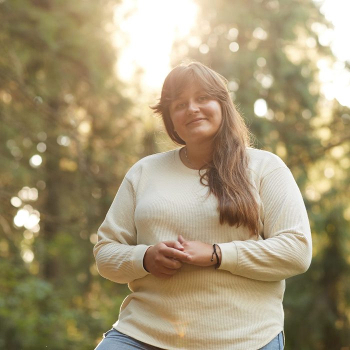 Portrait of young overweight woman smiling at camera while standing outdoors